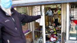 small Shop owners survey the damage to their store in Philadelphia, PA