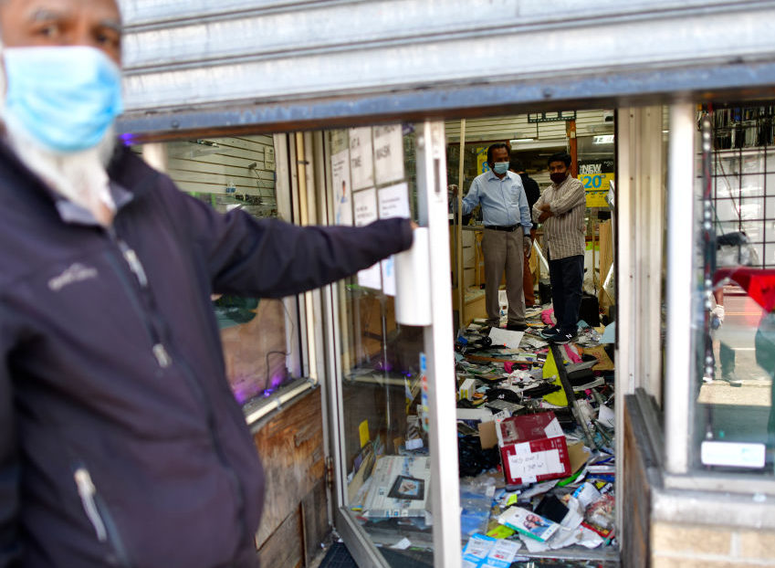 small Shop owners survey the damage to their store in Philadelphia, PA