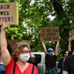 defund Protesters hold up signs on June 3, 2020
