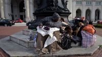 A woman sits with her dogs outside Union Station March 22, 2016 in Washington, DC (BRENDAN SMIALOWSKI/AFP via Getty Images)