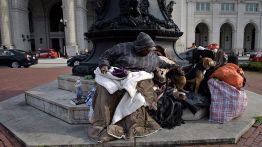 A woman sits with her dogs outside Union Station March 22, 2016 in Washington, DC (BRENDAN SMIALOWSKI/AFP via Getty Images)