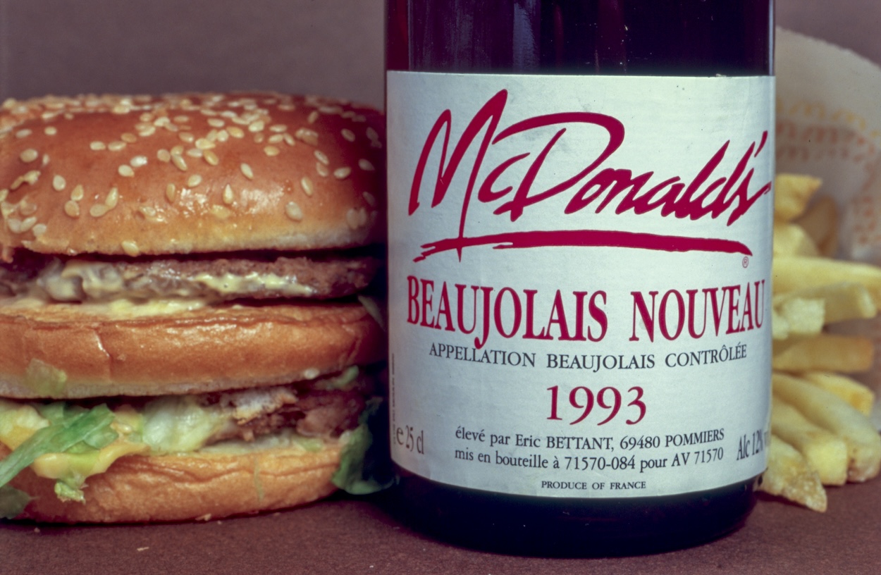 Une bouteille de beaujoulais nouveau à côté d'un repas McDonald's, France, 1994. (Photo by Robert DEYRAIL/Gamma-Rapho via Getty Images)