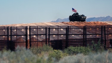 An eight-wheeled military vehicle patrols near the border wall which is being painted black after an order by US President Donald Trump, according to US Secretary of Homeland Security Kristi Noem, between Santa Teresa, New Mexico and Ciudad Juarez, Chihuahua, Mexico on August 28, 2025. 8 miles of metal barrier are under construction since July 15 in the El Paso Sector. (Photo by Herika Martinez / AFP)