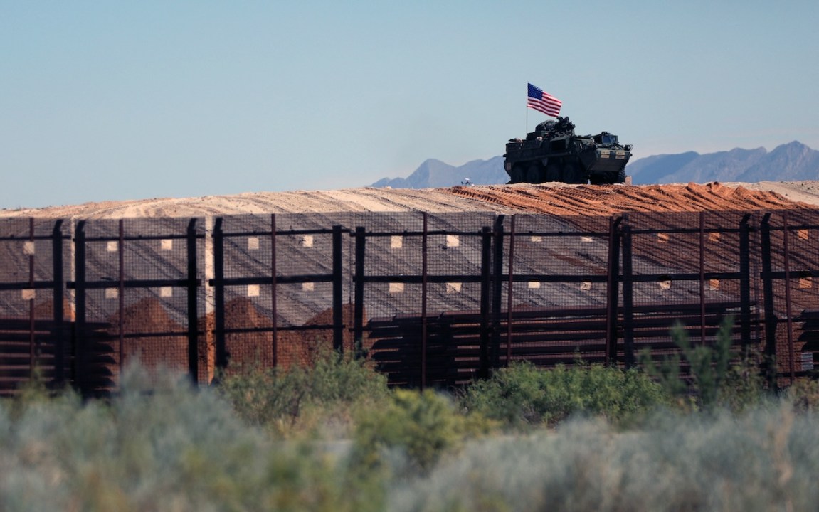 An eight-wheeled military vehicle patrols near the border wall which is being painted black after an order by US President Donald Trump, according to US Secretary of Homeland Security Kristi Noem, between Santa Teresa, New Mexico and Ciudad Juarez, Chihuahua, Mexico on August 28, 2025. 8 miles of metal barrier are under construction since July 15 in the El Paso Sector. (Photo by Herika Martinez / AFP)